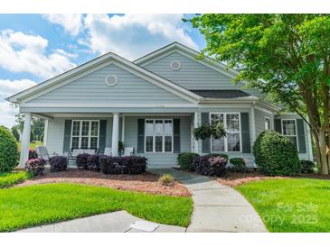 Charming single-story home with a covered front porch and well-manicured landscaping at 13360 Old Compton Ct, Pineville, NC 28134