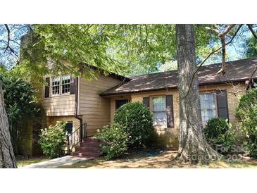 Charming two-story home featuring a brick facade and lush landscaping at 425 Roselawn Pl, Charlotte, NC 28211