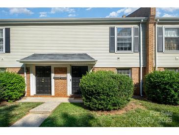 Inviting exterior of a townhome featuring a brick facade, dark doors, and manicured landscaping at 4609 Coronado Dr # N, Charlotte, NC 28212