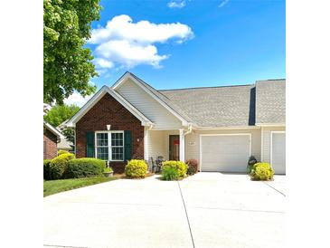 Charming single-story home with a brick facade, attached garage, and well-manicured landscaping, offering great curb appeal at 101 Keswick Ln, Mooresville, NC 28117