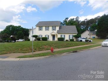 Charming two-story home with a well-maintained lawn and mature trees at 12803 Matisse Ln, Charlotte, NC 28215