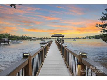 Picturesque waterfront property featuring a private dock with a gazebo, offering stunning sunset views at 17112 Green Dolphin Ln, Cornelius, NC 28031