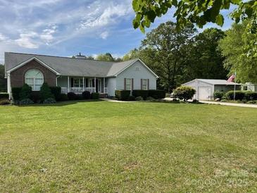 Charming single-story home featuring a well-manicured lawn, attached garage, and welcoming front porch at 260 Treebark Rd, Statesville, NC 28625