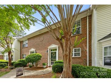Brick townhouse featuring a welcoming entryway, mature trees, and well-maintained landscaping at 3736 Melrose Cottage Dr, Matthews, NC 28105