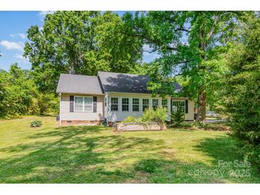 Charming home with lush green lawn and mature trees providing ample shade and curb appeal at 814 Independence Dr, Wingate, NC 28174