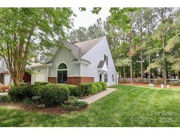 Charming home with manicured lawn, brick accents, and lush landscaping at 8233 Christmas Ct, Charlotte, NC 28216