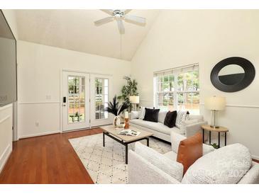 Bright living room with ceiling fan, hardwood floors, and French doors to the back yard at 8233 Christmas Ct, Charlotte, NC 28216