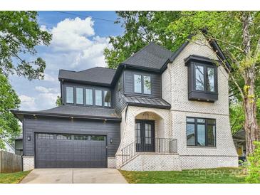 Stunning two-story home featuring a brick and wood exterior, dark trim, and attached two-car garage at 910 Everett Pl, Charlotte, NC 28205