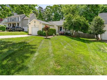 Charming single-story home with an attached garage, lush lawn, and mature landscaping at 11224 Amber Glen Dr, Charlotte, NC 28269