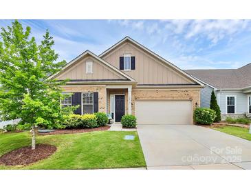 Charming brick home with a two-car garage, lush landscaping, and a welcoming entrance at 16012 Tulloch Rd, Charlotte, NC 28278