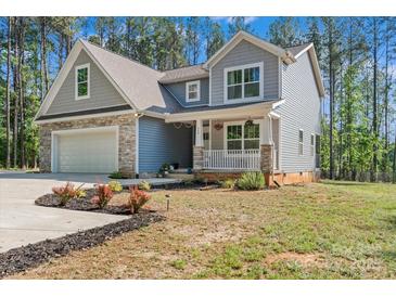 Charming two-story home features a stone-accented garage and inviting front porch at 539 Morrison Farm Rd, Troutman, NC 28166