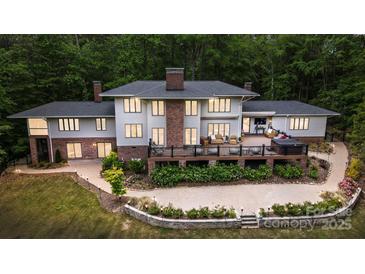 Expansive home exterior with brick accents, a multi-level deck, mature landscaping, and patio seating perfect for outdoor entertaining at 115 Forestcliff Ne Ct, Concord, NC 28025