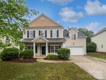 Charming two-story home with well-manicured lawn, black shutters, and inviting front porch at 15923 Prescott Hill Ave, Charlotte, NC 28277