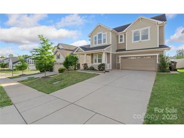 Beautiful two-story home with a welcoming front porch, two-car garage, and lush green lawn at 16134 Kelby Cv, Charlotte, NC 28278