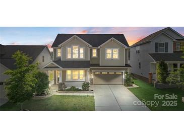 Charming two-story home featuring a welcoming front porch and a well-manicured lawn at 16134 Kelby Cv, Charlotte, NC 28278