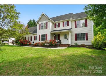 Charming two-story home featuring red shutters and a beautifully landscaped front yard at 305 Phillip Dr, Salisbury, NC 28146