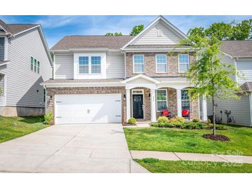 Beautiful two-story home showcasing a well-manicured lawn, brick accents, and a welcoming front porch with rocking chairs at 424 Preston Rd, Mooresville, NC 28117