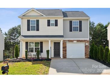 Charming two-story home featuring a covered front porch, neutral siding, and an attached garage with a stone facade at 509 Ellingsworth Ln, Charlotte, NC 28214