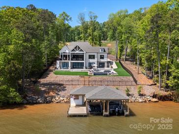Beautiful lakefront home with a pool, private dock, and lush green landscaping at 8044 Edgewater Dr # 100, Norwood, NC 28128