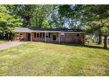 Charming, single-story brick home with a well-manicured lawn and mature trees, creating a welcoming curb appeal at 1141 Carolina Cir, Statesville, NC 28677