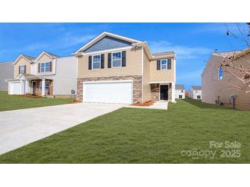 Two-story home with a two-car garage, stone accents, neutral siding, and a well-manicured lawn under a bright, blue sky at 14026 Wilson Mac Ln, Charlotte, NC 28278