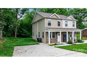 Two-story home with stone accents, a covered porch, and a well-maintained lawn and a concrete driveway at 1735 15Th Street Ne Pl, Hickory, NC 28601