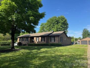 Charming brick home with lush green lawn and mature trees in a peaceful residential neighborhood at 174 Wintergreen Cir, Statesville, NC 28677