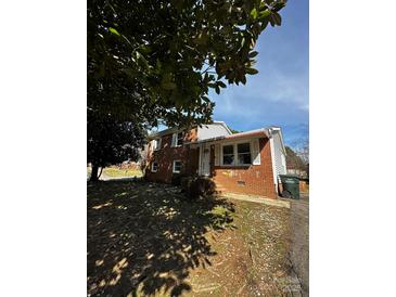 Charming brick home with white trim, mature landscaping, and a cozy, inviting front porch at 3048 Marigold Ln, Gastonia, NC 28052
