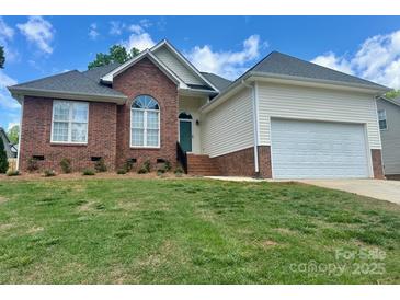 Charming brick and vinyl home with a well-manicured lawn and two-car garage at 3776 Kennedy Rd, Gastonia, NC 28056