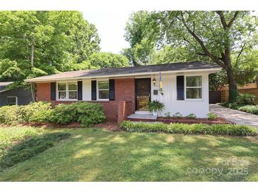 Charming red brick and white home with black shutters and a well-manicured lawn at 4361 Applegate Rd, Charlotte, NC 28209