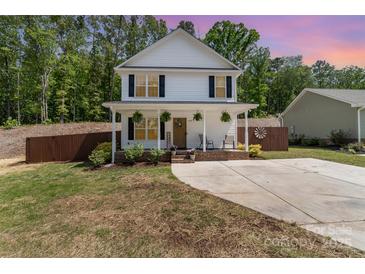Charming two-story home with a welcoming front porch, landscaped yard, and a long driveway at 658 Morgan Rd, Albemarle, NC 28001