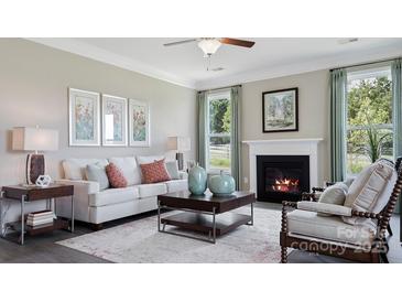 Inviting living room features a fireplace, plush white sofa, and neutral decor creating a cozy atmosphere at 7138 Butternut Oak Ter, Huntersville, NC 28078