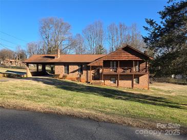 Charming brick home with a covered carport, second story balcony, and a well-maintained lawn at 1074 25Th Ne St, Hickory, NC 28601