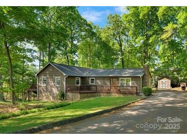 Charming single story home featuring a wooden deck, stone accents, and beautifully landscaped front yard with mature trees at 110 Lakeland Rd # 19, Mooresville, NC 28117