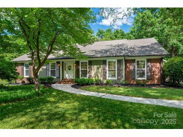 Charming single Gathering home featuring a well-manicured lawn, brick accents, and an inviting walkway to the front door at 1260 Piccadilly Dr, Charlotte, NC 28211