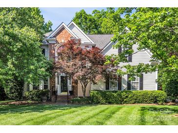 Charming two-story home with brick and vinyl siding, manicured lawn, and mature landscaping at 15000 Strathmoor Dr, Charlotte, NC 28277
