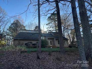 Charming single-story home with a unique roofline and inviting front entrance nestled among trees at 2 Sunrise Point Rd, Lake Wylie, SC 29710