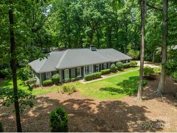 Aerial view of a charming home featuring lush landscaping, mature trees and a well-maintained lawn at 532 Courtney Ln, Matthews, NC 28105