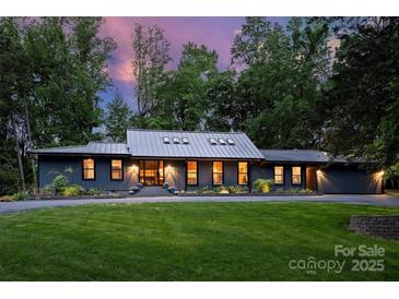 Beautiful ranch-style home with a metal roof, manicured lawn and professional landscaping at 6108 Phyliss Ln, Mint Hill, NC 28227