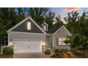 Charming home featuring a blend of stone and siding, a two-car garage, and a beautifully landscaped front yard at 7620 Porrera St, Charlotte, NC 28214