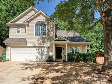 Charming two-story home with attached two-car garage, lush landscaping, and mature trees at 7923 Shiny Meadow Ln, Charlotte, NC 28215