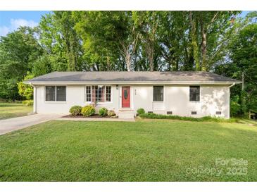 Charming single-story home with a well-manicured lawn and a vibrant red front door at 808 Sharon Dr, Waxhaw, NC 28173