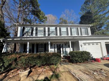 Charming two-story home with black shutters, covered front porch, and well-maintained landscaping at 10304 Shady Rest Ln, Charlotte, NC 28214