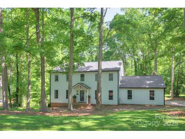Charming two-story home with a well-maintained lawn and mature trees offering shade and curb appeal at 10501 Stonemede Ln, Matthews, NC 28105