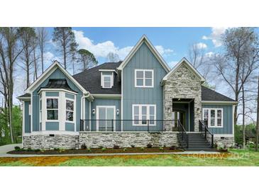 Charming blue home featuring stone accents, a covered entryway, and a well-maintained front yard at 149 Shady Cove Rd, Troutman, NC 28166