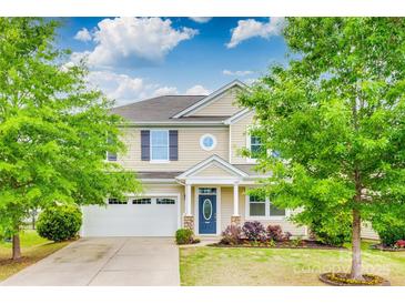 Charming two-story home featuring a well-manicured lawn, blue door, and attached two-car garage at 1507 Arcadia Bluff Dr, York, SC 29745