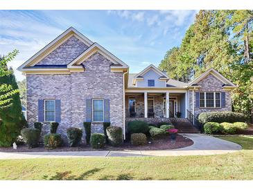 Charming brick home features mature landscaping, two-car garage and inviting front porch at 162 Kenway Loop, Mooresville, NC 28117