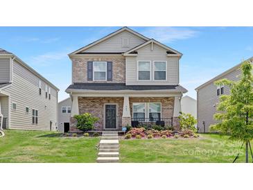 Beautiful two-story home with a brick facade, landscaped front yard, and welcoming entrance at 363 Cedar Knoll Cir, Pineville, NC 28134
