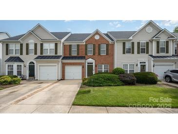 Charming townhouse with brick and siding exterior, complemented by a well-maintained lawn and attached garages at 4208 Carl Parmer Dr, Harrisburg, NC 28075