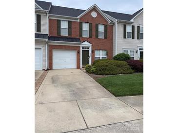 Charming brick townhome with a one car garage and well manicured lawn at 4208 Carl Parmer Dr, Harrisburg, NC 28075